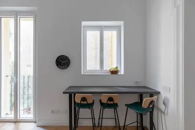 a dining room table with two chairs and a clock on the wall at iFlat Elegance and comfort in Monti in Rome