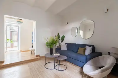 a living room with a blue couch and a round mirror at iFlat Blue Cozy Loft near Saint Peter in Rome