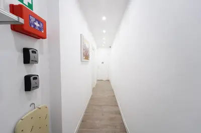 a hallway with white walls and a surfboard on the wall at Rome Vatican City Whole Apartment 3 Private Rooms in Rome