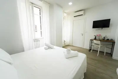a white bedroom with two beds and a television at Rome Vatican City Whole Apartment 3 Private Rooms in Rome