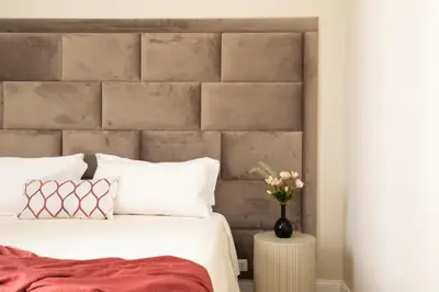 a bedroom with a bed with a concrete headboard at Spanish Steps Caesar Suites in Rome