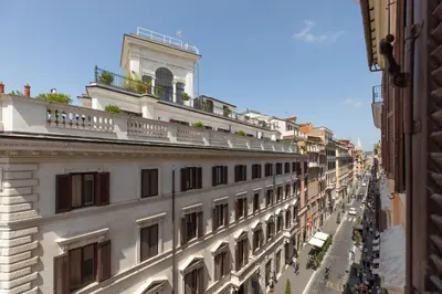 a city street with a building with a balcony at Spanish Steps Caesar Suites in Rome