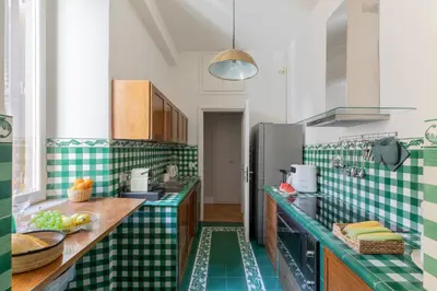 a kitchen with green and white tiles on the counters at Spanish Steps Caesar Suites in Rome