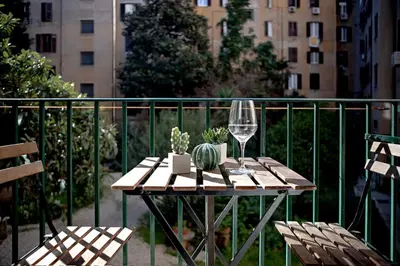 a table with a wine glass and cactus on a fence at Sui Generis Casa appartamento per vacanze in Rome