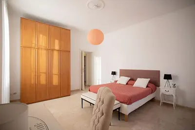 a bedroom with a bed and a large wooden cabinet at Sui Generis Casa appartamento per vacanze in Rome