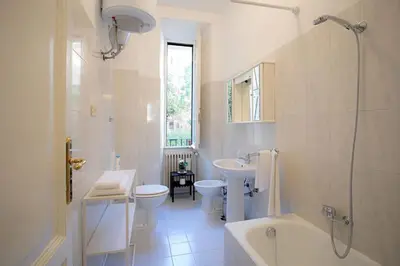 a white bathroom with a tub and a toilet and a sink at Sui Generis Casa appartamento per vacanze in Rome