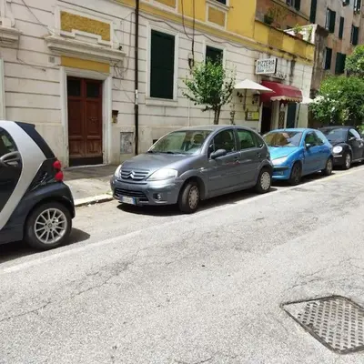 a row of cars parked on the side of a street at Sui Generis Casa appartamento per vacanze in Rome