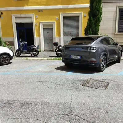 a car parked in a parking lot next to a motorcycle at Sui Generis Casa appartamento per vacanze in Rome