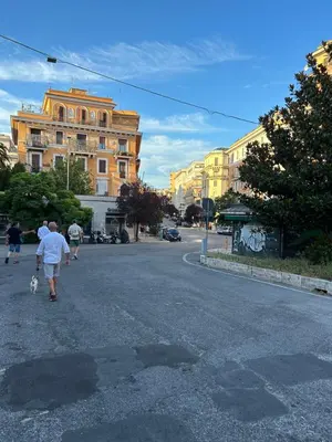 a man walking a dog down a city street at Sui Generis Casa appartamento per vacanze in Rome