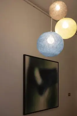 a television with three lights hanging from a wall at Sui Generis Casa appartamento per vacanze in Rome