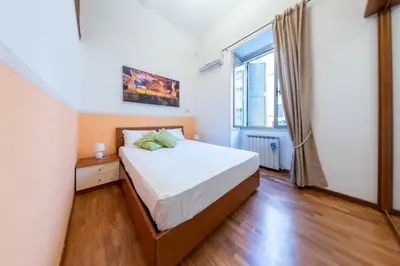 a bedroom with a bed and a large window at Trastevere - Viaggio a Roma Antica in Rome
