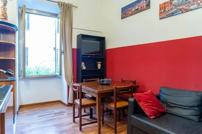 a dining room with a table and a red wall at Trastevere - Viaggio a Roma Antica in Rome