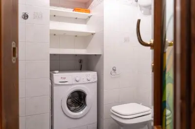 a small bathroom with a washing machine and a toilet at Trastevere - Viaggio a Roma Antica in Rome