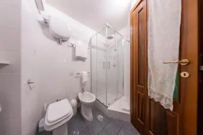 a bathroom with a toilet and a glass shower at Trastevere - Viaggio a Roma Antica in Rome