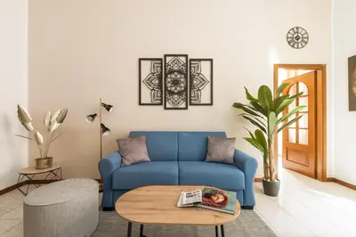 a living room with a blue couch and a table at Imperial Nazionale in Rome