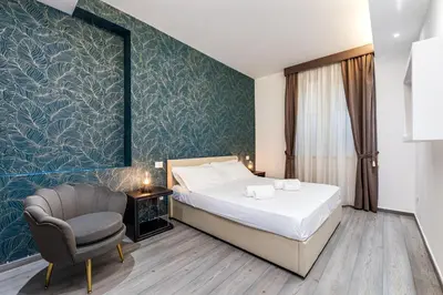 a bedroom with a bed and a chair at Spagna Boutique Suites in Rome