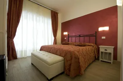 a bedroom with a bed and a chair and a window at Atlantis Inn Roma in Rome