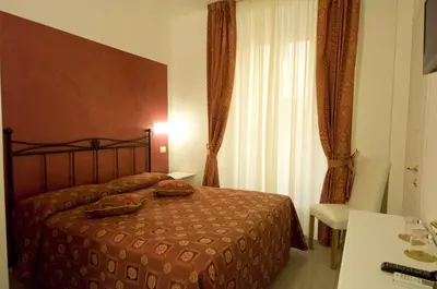 a bedroom with a bed and a table and a window at Atlantis Inn Roma in Rome