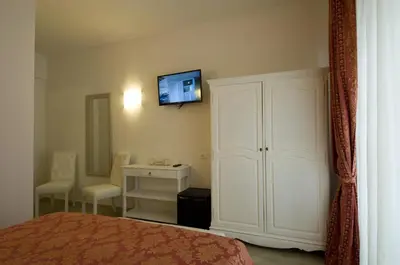 a bedroom with a white cabinet and a tv on the wall at Atlantis Inn Roma in Rome