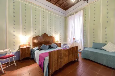 a bedroom with a large bed and a chair at Casa Savelli in Rome