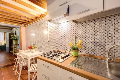 a kitchen with a stove and a sink and a table at Casa Savelli in Rome