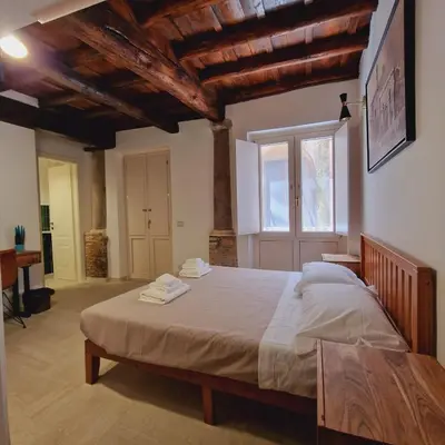 a bedroom with a large bed and a window at Casina Giubbonari in Rome