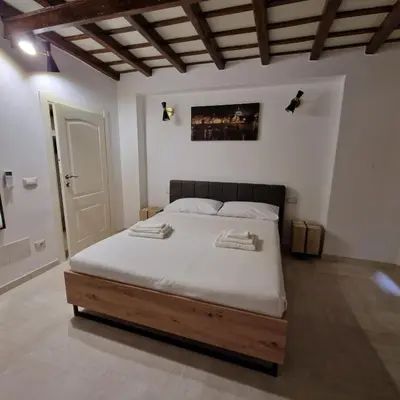 a bedroom with a large bed with a wooden frame at Casina Giubbonari in Rome