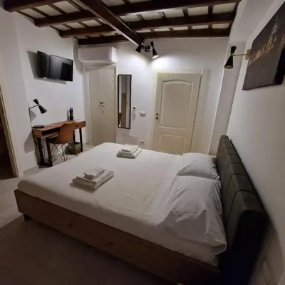 a bedroom with a large bed with white sheets at Casina Giubbonari in Rome