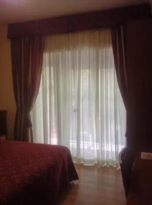 a bedroom with a bed and a window with curtains at Guglielmo Marconi House in Rome