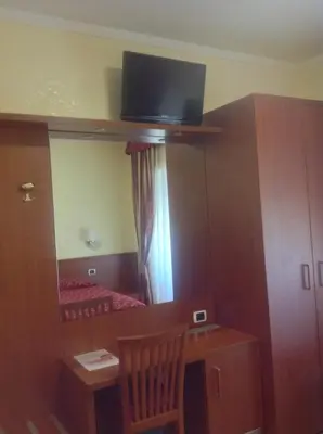 a small room with a desk and a tv on the wall at Guglielmo Marconi House in Rome