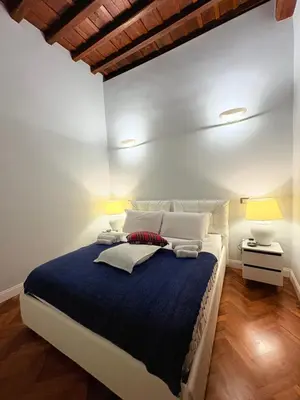 a bedroom with a large bed with a blue blanket at DOMVS SPAGNA Via Gregoriana in Rome