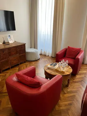 a living room with two red chairs and a coffee table at DOMVS SPAGNA Via Gregoriana in Rome
