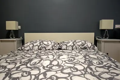 a bed with a black and white comforter and two lamps at The Photos Room B&B in Rome