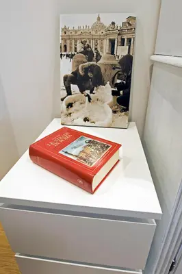 a book sitting on top of a white shelf at The Photos Room B&B in Rome