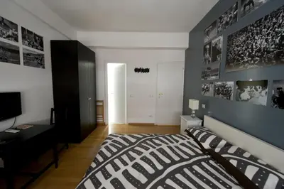 a bedroom with a black and white bed and a desk at The Photos Room B&B in Rome