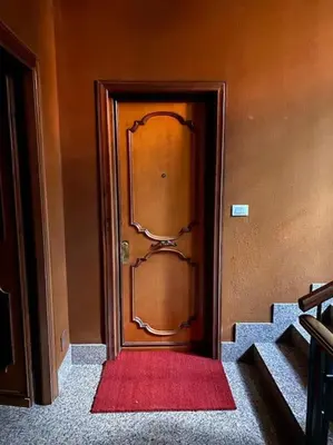 a wooden door with a red rug in a hallway at Alfredo Luxury house in Rome