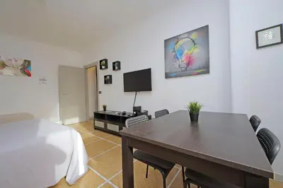 a bedroom with a table and chairs and a tv at The colours rooms guest house in Rome