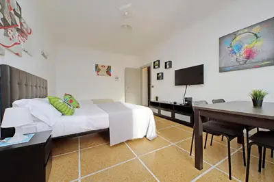 a bedroom with a bed and a desk and a television at The colours rooms guest house in Rome