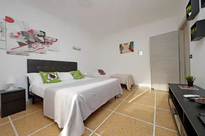 a bedroom with a large white bed with green pillows at The colours rooms guest house in Rome
