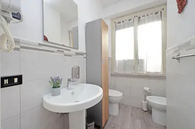 a white bathroom with a sink and a toilet at The colours rooms guest house in Rome
