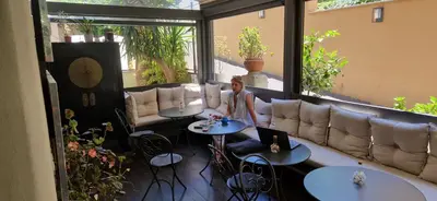 a woman standing in a room with tables and a couch at Hotel Valerì in Rome