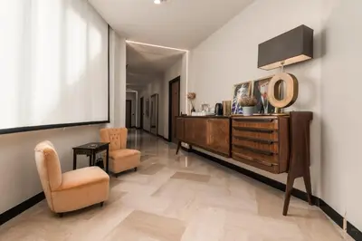 a living room with a dresser and a chair at Hotel Valerì in Rome