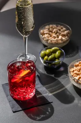 a table with a glass of wine and bowls of nuts at Hotel Valerì in Rome