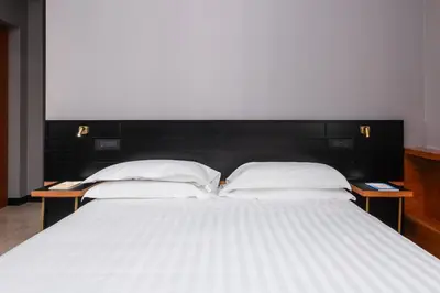 two beds with white pillows in a room at Hotel Valerì in Rome