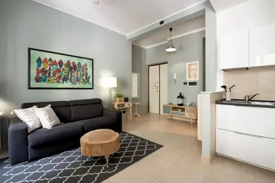 a living room with a black couch and a kitchen at Olimpico Apartment Flaminio in Rome
