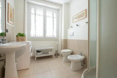 a white bathroom with a toilet and a sink at Olimpico Apartment Flaminio in Rome