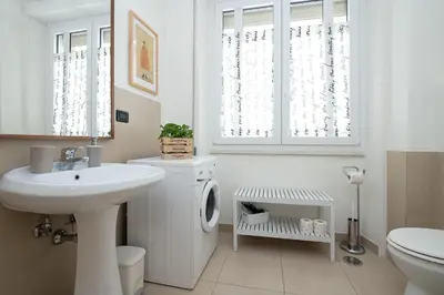 a white bathroom with a sink and a washing machine at Olimpico Apartment Flaminio in Rome