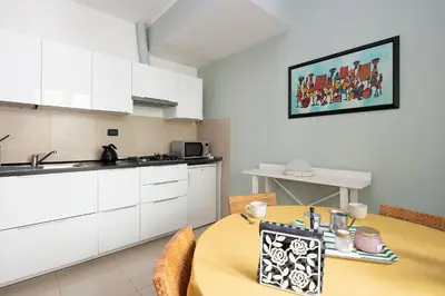 a kitchen with a yellow table with chairs and a counter at Olimpico Apartment Flaminio in Rome