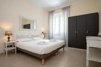 a bedroom with a large white bed with a mirror at Olimpico Apartment Flaminio in Rome