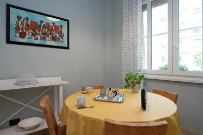 a dining room table with a yellow table cloth and chairs at Olimpico Apartment Flaminio in Rome